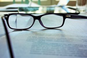 A pair of glasses sitting on top of mediation documents