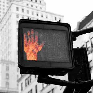 Street sign with hand indicating "STOP"